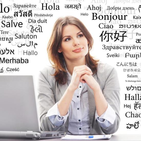 Kvinde sidder med sin pc. Rundt omkring hende står Hallo på mange forskellige sprog.
