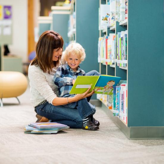 Kvinde og lille dreng, der læser