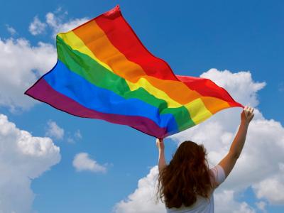 kvinde der holder et regnbueflag