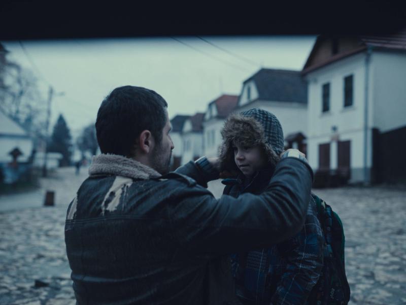 mand på hug foran dreng, dreng får hætte på