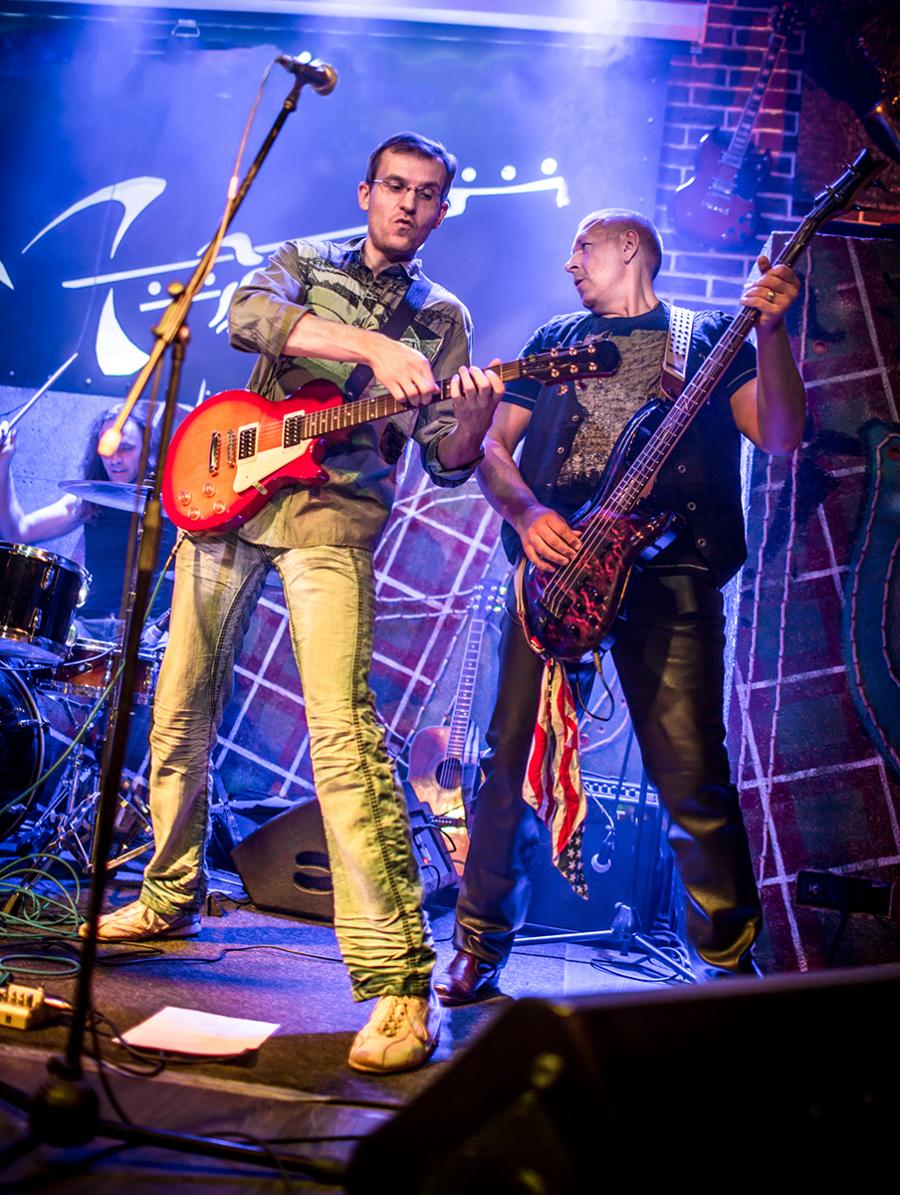 To musikere på scenen spiller guitar